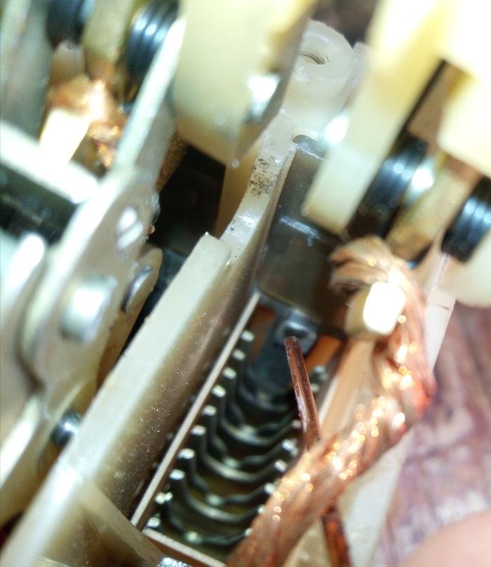 Проволочка указывает на неподвижный контакт и "ребра" дугогасительной камеры.