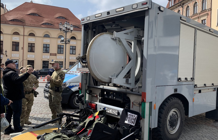 Саперная машина с костюмом и камерой. На заднем плане - дом с глазками.