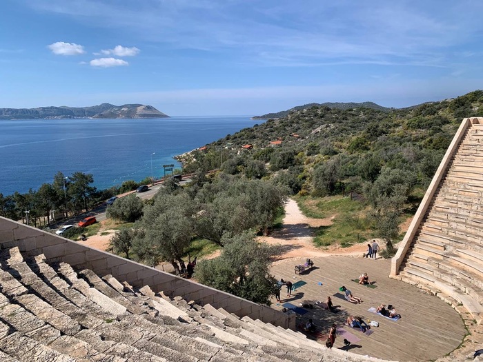 Амфитеатр, йога внизу, а на дальнем плане видно греческий остров