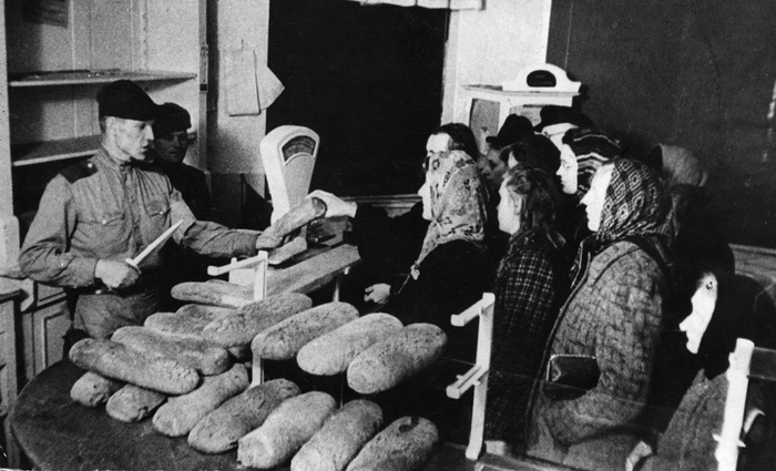 Советский солдат раздаёт хлеб немецким женщинам. Берлин, май 1945 года