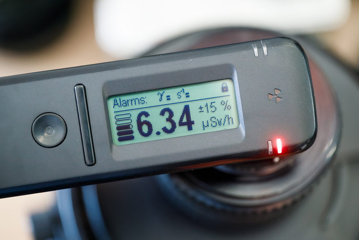 Задняя линза фонит заметно сильнее (а еще излучает бета- и альфа-частицы, которые данный прибор не видит)