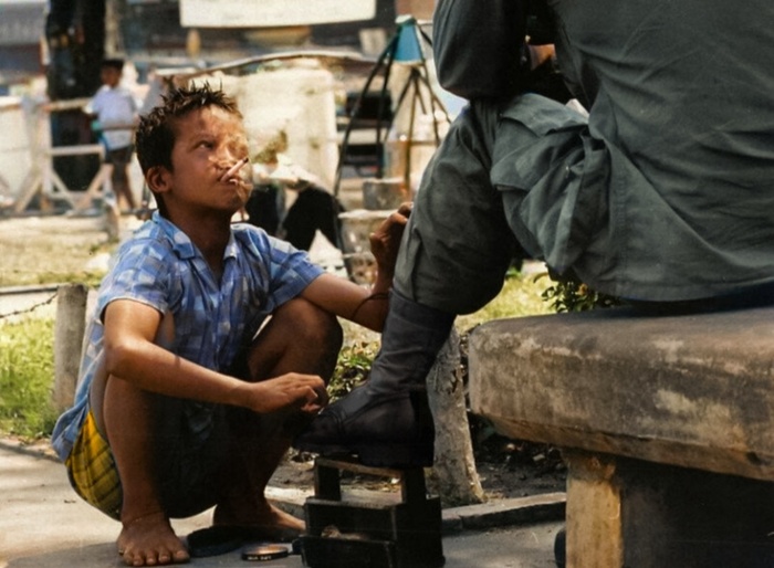 Вьетнам. Вьетнамский мальчишка начищает сапоги американскому солдату