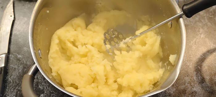 Половину картофеля которая полностью сварилась размалываю толкушкой в пюре