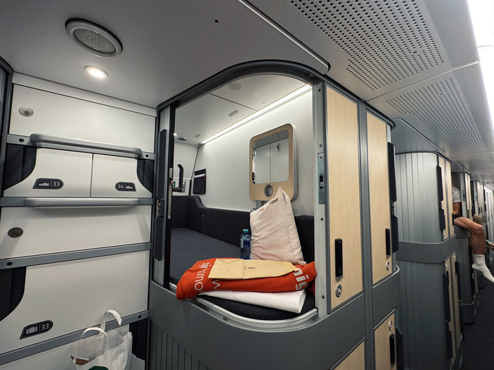 Внутри капсулы есть всё что нужно: розетки, свет, столик, кондиционер и окно со шторкой. В соседнюю капсулу есть дверца, если вдруг вы едете не один.