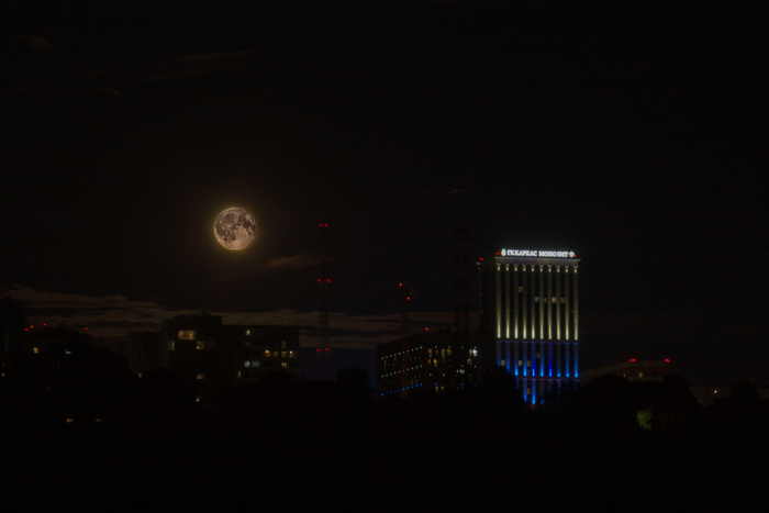 Экспериментировал со склейкой фотографий, тут всё простенько - две, одна поярче, другая потемнее, чтобы был яркий город и тёмная луна. Получился интересный эффект, будто Луна прозрачная и подсвечена сзади. Жаль город мыльненько получился.