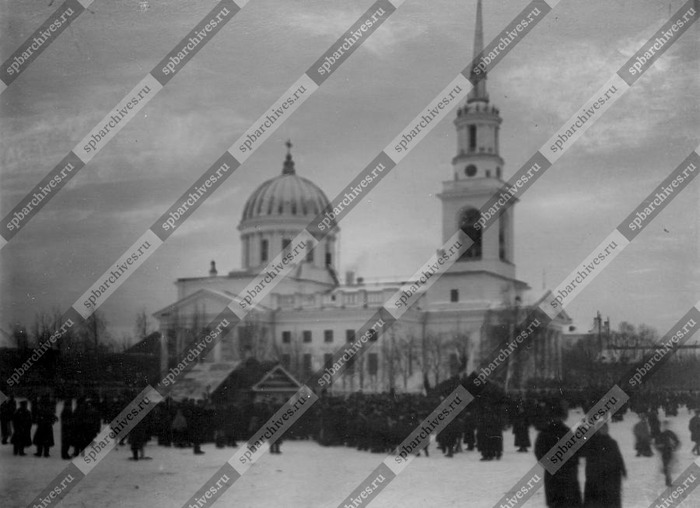 Группа людей около Андреевского собора наблюдает за опытом Ф.Г.Бабаева – “негорючие материалы”. Кронштадт, 1898 год. Фото из платного доступа архива кинофотофонодокументов Санкт-Петербурга.