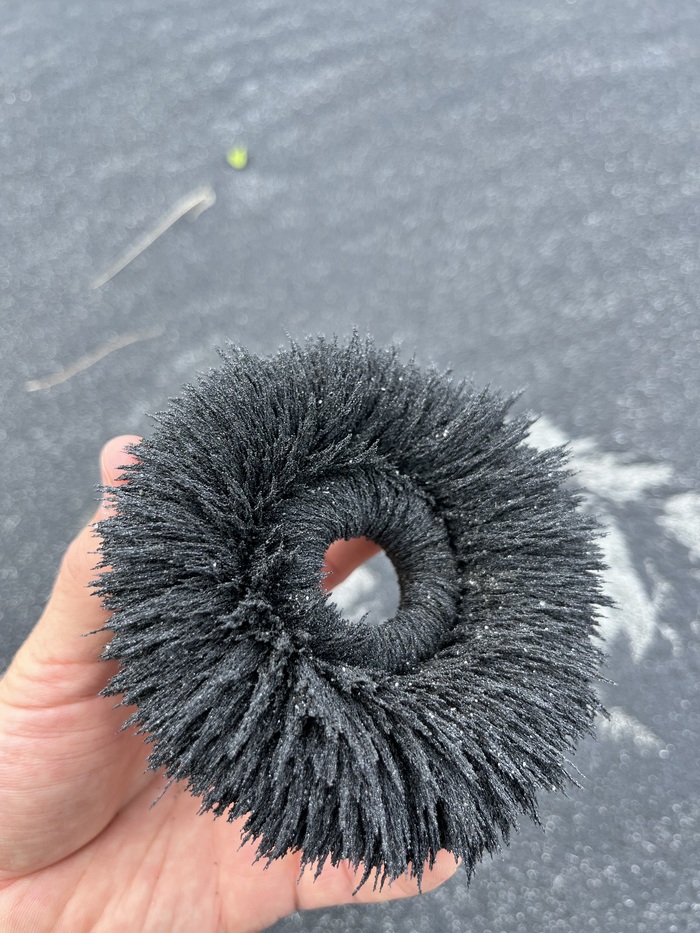 Черные породы побережья притягиваются к магниту и визуализируют линии магнитного поля.