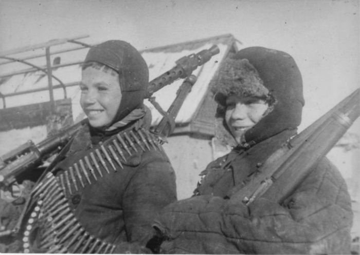 Саша Иващенко несёт сдавать немецкий пулемет MG-34, а Саша Величенко – карабин Маузер