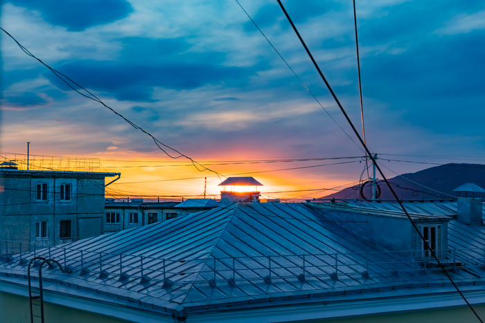 Над жестяными крышами обшарпанных домов...