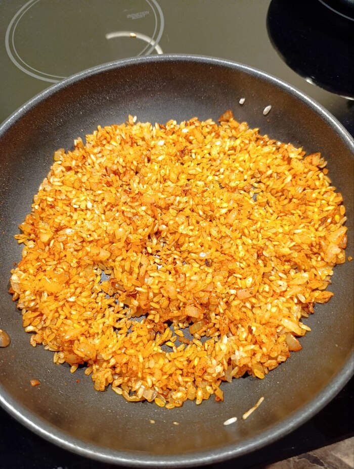 В сковороду к луку с чесноком и рисом всыпаем сладкую паприку и перемешиваем
