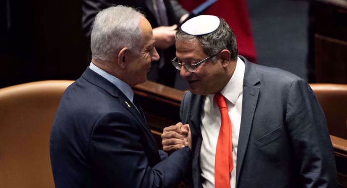 Премьер-министр Израиля Биньямин Нетаньяху и Итамар Бен-Гвир пожимают руки после того, как израильский кабинет министров одобрил предложение Нетаньяху о переназначении Бен-Гвира на пост министра так называемой национальной безопасности.