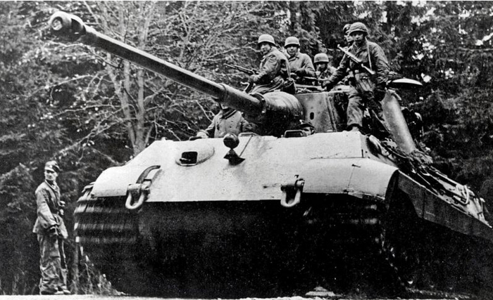 Немецкие парашютисты едут на броне танка Pz.Kpfw. VI Ausf. B «Тигр II» («Королевский тигр») во время наступления в Арденнах